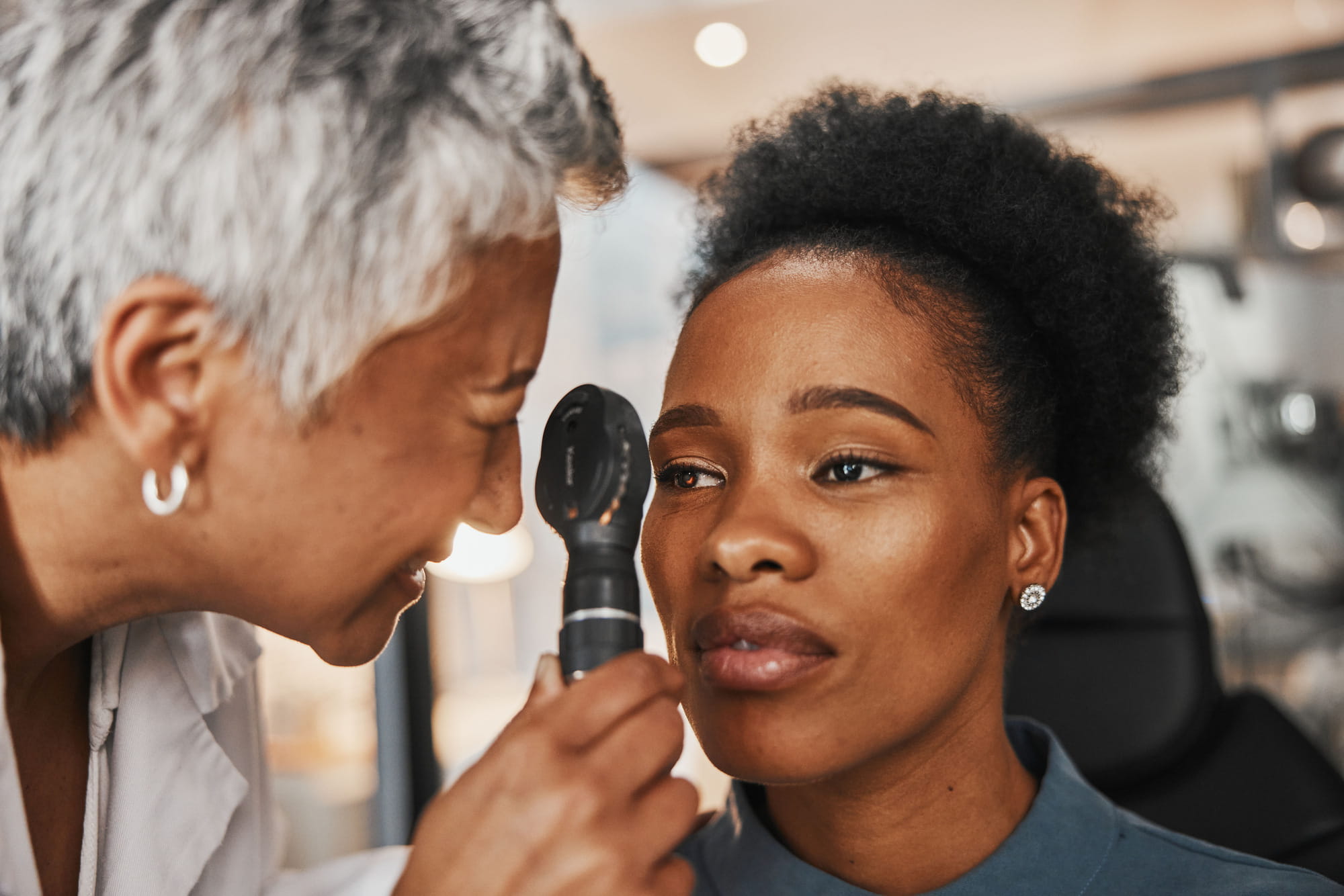 Laser, senior doctor or black woman in eye exam for eyesight at optometrist office. Mature optician.